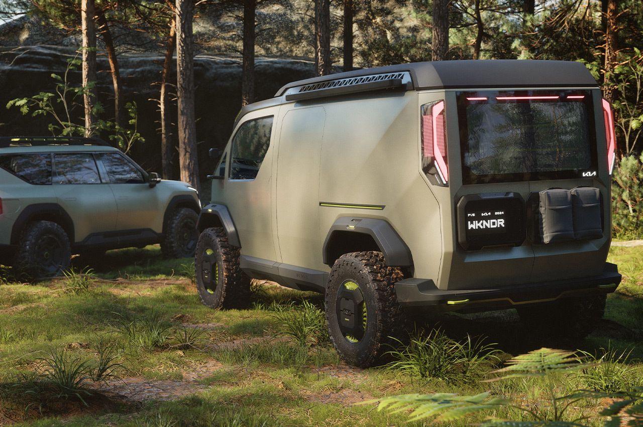 Furgoneta Kia "WKNDR" aparcada junto al vehículo "ADVNTR" en el bosque