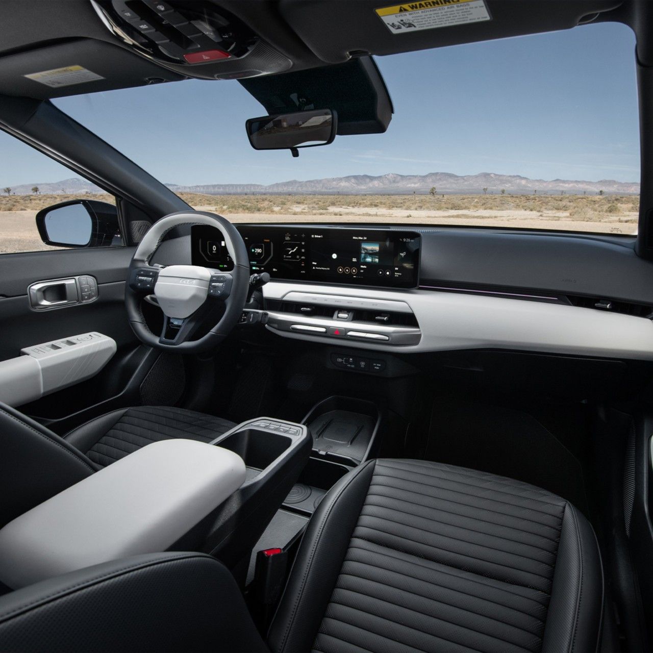  Interior del Kia EV4 2026, vista en tres cuartos delantera de la cabina, con la pantalla digital, volante bicolor y asientos de cuero SynTex