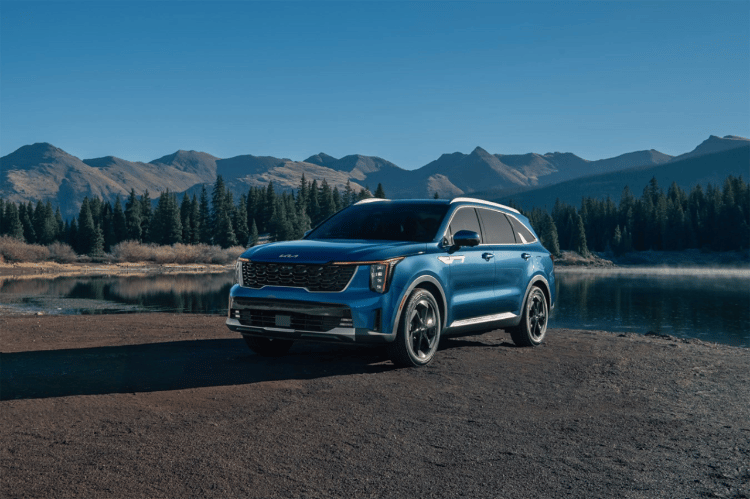  2025 Kia Sorento Hybrid in blue, three-quarter front view, parked in front of the mountains